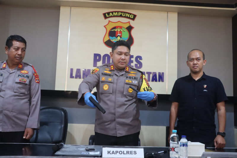 Kapolres Lampung Selatan, AKBP Yusriandi Yusrin menunjukan barang bukti senjata jenis Airsoft Gun yang digunakan pelaku untuk mengancam petugas Loket Pelabuhan Bakauheni Lampung ( poto Humas Polres Lamsel ).