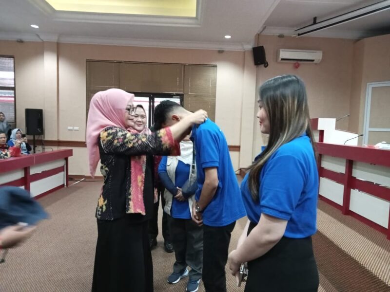 Pj Sekda Lamsel Intji Indrianti, menyematkan tanda peserta KKN Unila (poto: Juantoro).
