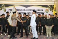 Gubernur Rahmat Mirzani Djausal menyerahkan bendara petaka kepada ketua IJP  Periode 2025–2028 Abung Mamasa di Balai Keratun Lt. III, Kamis (19/6/). (Poto Diskomifo Pemprov Lampung.)