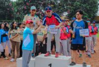 Sekretaris Daerah Provinsi Lampung, Marindo Kurniawan menyerahksn piala kepada Klub Softball asal Lampung, Two Pillar yang berhasil jadi juara pertama (ist).