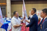 Poto: Ketua KONI Lampung, Tofik Hidayat, menyerahkan bendera petaka kepada ketua Ketua PBPI Lampung, H. Tomy Rianta Putra tanda masuknya PBPI di KONI Lampung ( ist ).