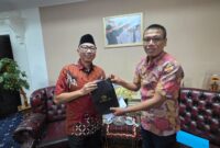 Poto: Ketua PWI Lampung Wirahadikusumah Saat menyerahkan batik HPN kepda Gubernur ( dok PWI Lampung).