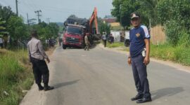 Petugas kepolisian dan Disbuh Lampung Selatan tengah mengatue lalu lintas, ketika truk fuso patah As roda di evakuasi menggunakan alat berat. (Foto.Dishub Lamsel)
