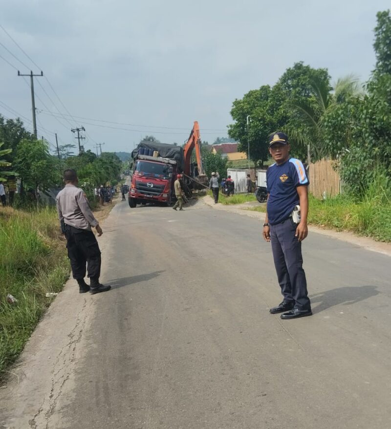 Petugas kepolisian dan Disbuh Lampung Selatan tengah mengatue lalu lintas, ketika truk fuso patah As roda di evakuasi menggunakan alat berat. (Foto.Dishub Lamsel)