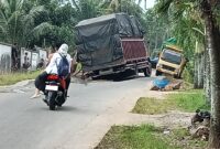 Dua mobil sarat muatan berlebih akibatkan jalan raya Desa Kekiling, Kecamatan Penengahan, Lamsel putus. (Foto.Juwantoro)