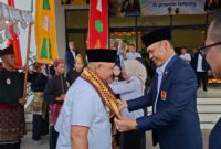 Poto: ketua KONI Lampung memberikan selendang saat menerima kunjungan Ketua KONI Banten, Agus Rasid, ( dok KONI Lampung).