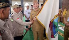 Bupati Lampung Selatan Radityo Egi Pratama serahkan bendera pataka kepada ketua regu JCH dalam rangkaian pelepasan keberangkatan JCH asal Lamsel. (foto.Diskominfo Lamsel)