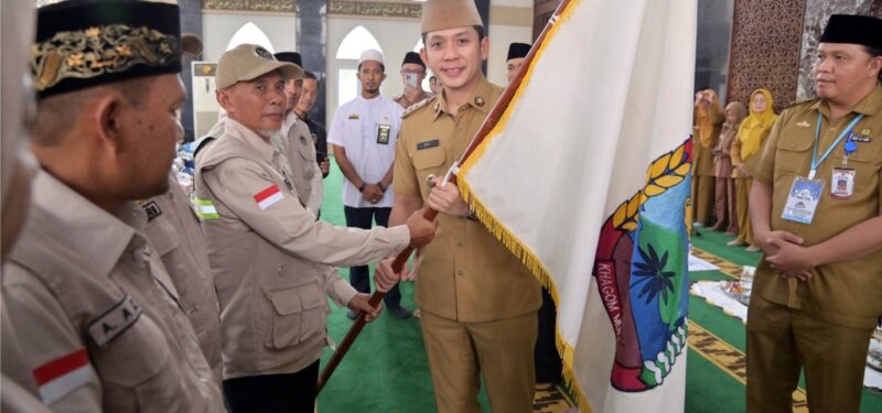 Bupati Lampung Selatan Radityo Egi Pratama serahkan bendera pataka kepada ketua regu JCH dalam rangkaian pelepasan keberangkatan JCH asal Lamsel. (foto.Diskominfo Lamsel)