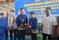 Bupati Lampung Selatan Radityo Egi Pratama menyerahkan pelakat kepada Yosep, dalam kegiatan Muskab VIII Kadin Lamsel. (Foto.Juwantoro) 